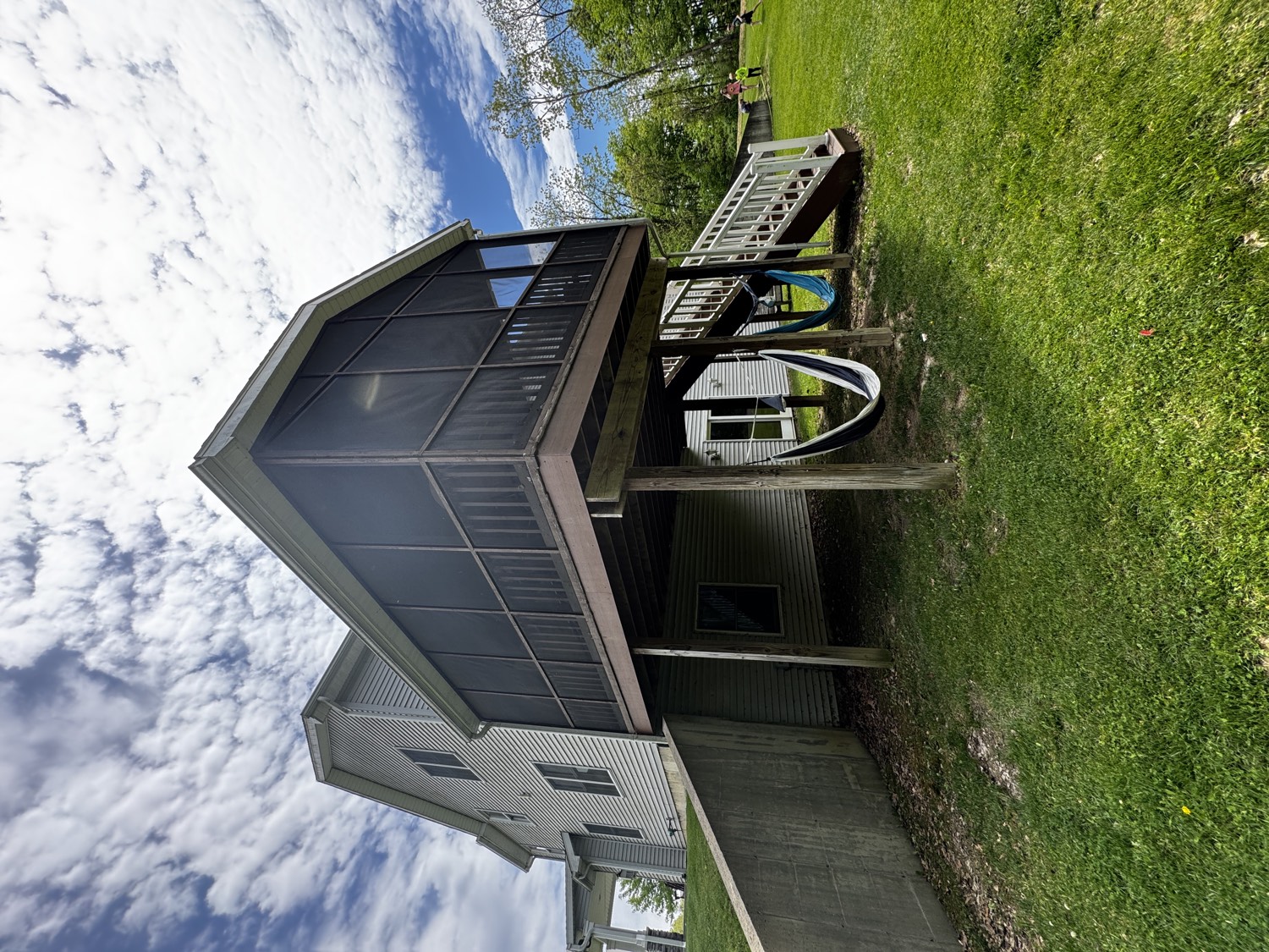 Elevated screened porch and deck on a raised foundation with staircase