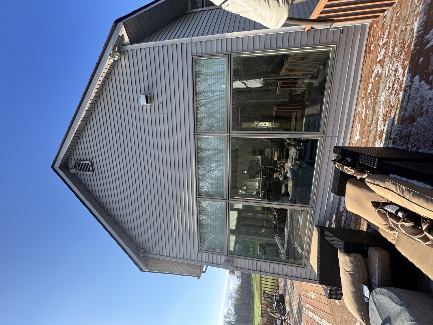 Rear of a residential home with a large window wall and patio